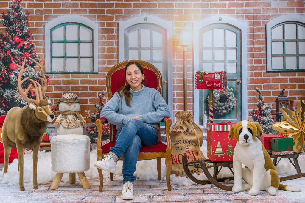 femme dans chaise rouge devant un décors de photo de Noël